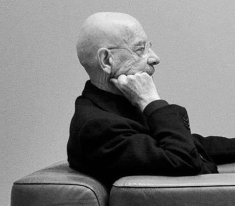 A side profile portrait of Mario Bellini sitting in a club chair
